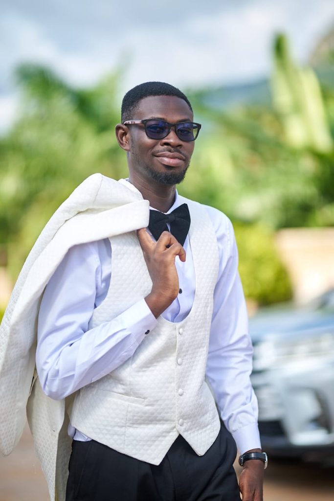 Dr Roland Badu founder and editor of RoadBlueprint wearing a formal vest and sunglasses outdoors