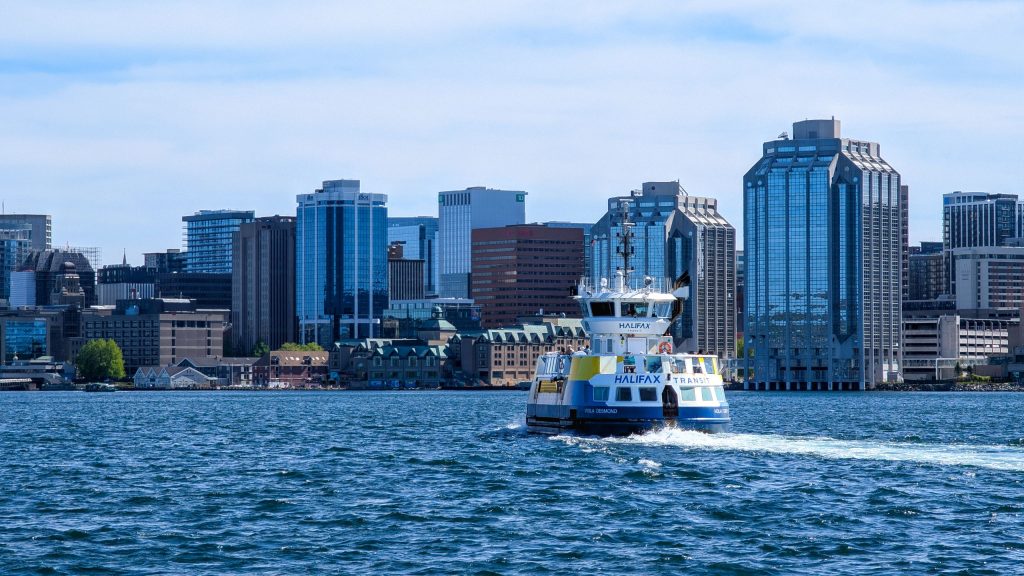 Passenger ferry sailing across blue water toward the downtown Halifax waterfront skyline in Nova Scotia