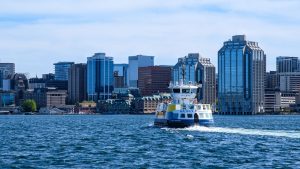 Passenger ferry sailing across blue water toward the downtown Halifax waterfront skyline in Nova Scotia