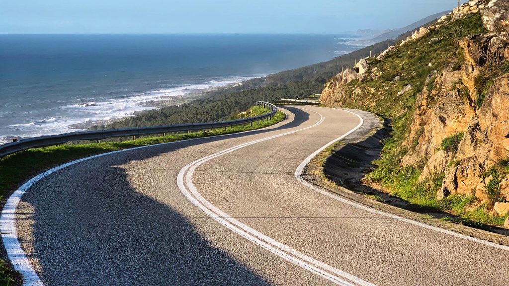 Curving paved road along steep coastal cliffs overlooking the ocean on Pacific Coast Highway in Big Sur California