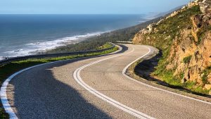 Curving paved road along steep coastal cliffs overlooking the ocean on Pacific Coast Highway in Big Sur California