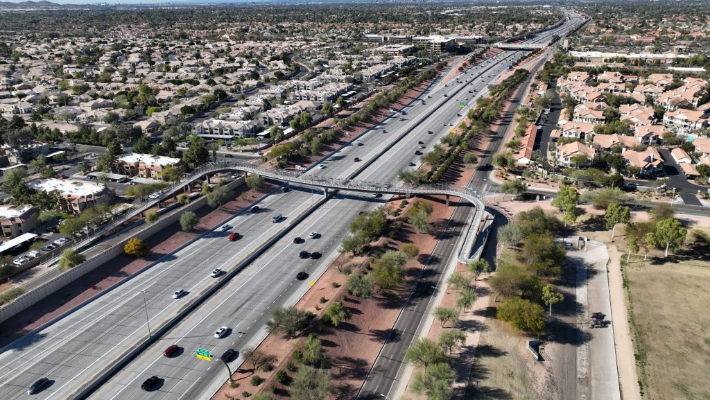 Aerial view of a multi-lane highway running through a desert residential neighborhood in Scottsdale, Arizona.
